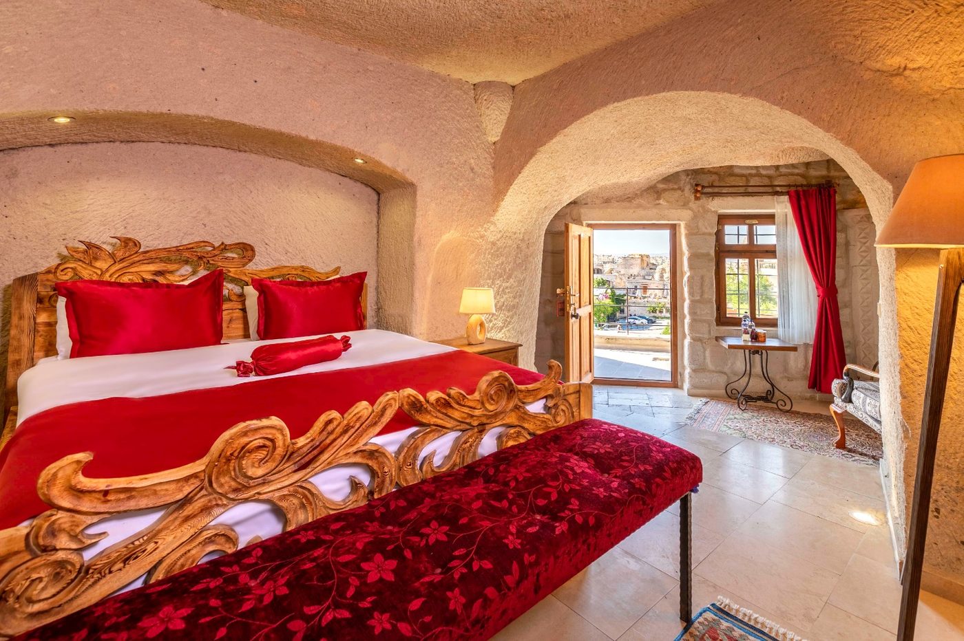 Quarto de hotel caverna na Capadócia com teto abobadado escavado na rocha e cama de madeira entalhada